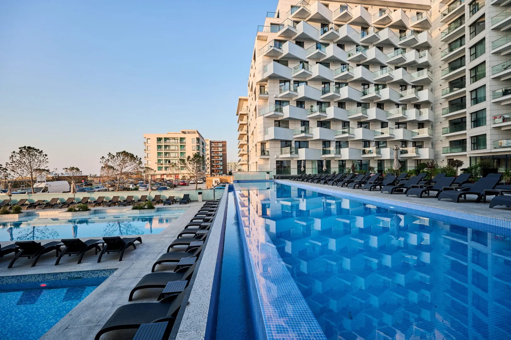 Piscina exterioară a resortului Alezzi Infinity, cu șezlonguri